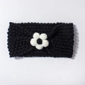 Close-up of black knitted baby headband with a white crochet flower detail and soft texture - Black