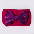 Détail du bandeau bébé avec un grand nœud pailleté sur un tissu en nylon doux - Bordeaux