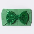 Gros plan d'un bandeau en nylon pour bébé avec un grand nœud en paillettes vertes - Vert