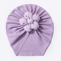 Detailansicht der lila Babymütze mit großer 3D-Blume und weicher, gerippter Stoffstruktur - Lila