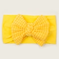 Detalle de la diadema amarilla para bebé con lazo de punto gofre y textura suave de tela - Amarillo Brillante