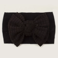 Detail view of baby headband featuring a black waffle knit oversized bow decoration - Black