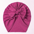 Close-up of bright rose pink rib-knit baby turban hat with a large decorative bow detail - Deep Purple