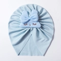 Detail of light blue ribbed knit baby hat featuring cute plush bow and eyelash embroidery - Blue