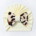 Detail einer Baby-Turbanmütze aus Rippstrick mit einer großen Schleife im Leopardenmuster - Beige
