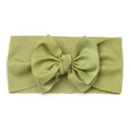 Détail de la texture en maille côtelée verte sur un bandeau à nœud doux pour bébé - Vert