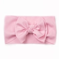 Detailed view of pink ribbed fabric baby headband featuring a large double bow design - Pink