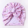 Detail of pink waffle knit baby hat with unicorn patterns and a large bow tie - Pink