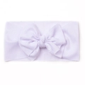 Detailed macro view of soft ribbed knit texture on a baby bow headband for infants - White