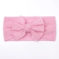 Detail eines rosa Baby-Stirnbands aus Mesh mit einer großen mehrlagigen Schleife - Rosa