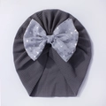 Detailed texture of dark grey baby turban hat featuring a large grey bird print bow - Gray
