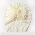 Dettaglio cappello neonato in pizzo bianco con fiocco giallo e rete a stelle scintillanti - Beige