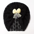 Detail of hollow floral lace baby beanie with yellow bow and central pearl accent - Black