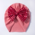 Detail of pink ribbed baby turban hat featuring a large red bow with silver star print - Pink