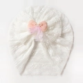 Dettaglio del turbante in pizzo per neonati con fiocco rosa, perle e decoro in mesh - Bianco