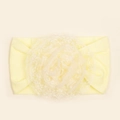 Detail van zachte lichtgele babyhoofdband met gelaagde kanten bloem en elastiek - Beige