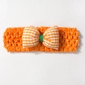 Vue détaillée d'un bandeau en crochet orange avec nœud à carreaux pour bébés - Orange