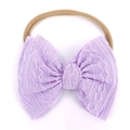 Detalle de la diadema para bebé en color lila con lazo suave de punto trenzado - Morado