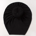 Close-up of black ribbed knit baby turban hat with a large donut knot on white background - Black