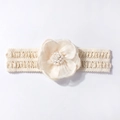 Détail du bandeau bébé montrant la maille, la fleur en dentelle 3D et les perles - Beige