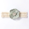 Détail d'un bandeau en dentelle pour bébé avec fleur en tissu vert et perles blanches - Vert