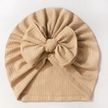 Détail du bonnet turban bébé avec texture côtelée et grand nœud en tissu beige doux - Café Clair