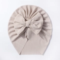Detailed view of baby ribbed knot hat with a large bow in champagne cream color - Light Coffee