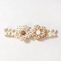 Detail eines weißen Spitzen-Babystirnbandes mit zwei Stoffblumen und gepunktetem Muster - Punktemuster Stil (B)