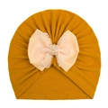 Detail of baby turban hat with ginger yellow knit fabric, lace bow, and faux pearls - Turmeric