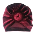 Detail eines weinroten Baby-Turbans aus Samt mit weichem Donut-Knoten auf weißem Grund - Burgunderrot
