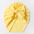 Detail of baby turban hat showing textured yellow knit fabric and a large bow - Yellow