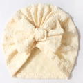 Detailansicht der cremegelben Baby-Mütze mit Herz-Jacquard-Muster und großer Schleife - Beige