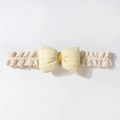 Dettaglio della fascia per neonati in pizzo beige con fiocco a quadretti gialli - Giallo