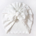 Detail der Baby-Turban-Mütze mit weißem Jacquard-Stoff und einer großen Schleife - Weiß