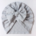 Detailed view of light blue baby hat with jacquard texture and big bow detail - Blue