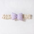 Detailaufnahme von Baby-Spitzenstirnband mit fliederfarbener Gingham-Schleife - Lila