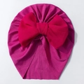 Detail der Baby-Turban-Mütze mit großer roter Chiffonschleife und feiner Rippenstruktur - Rosenrot
