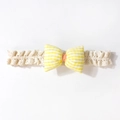 Dettaglio del fiocco a quadretti gialli e della morbida fascia in pizzo beige per neonati - Beige