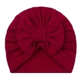 Close-up of dark red herringbone knit baby turban hat with a large soft decorative bow - Red