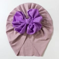 Detailed close-up of pink ribbed baby beanie featuring a large purple bow decoration - Purple