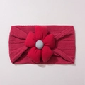 Détail d'un bandeau pour bébé en tricot rouge foncé avec une grande fleur en tissu doux - Bordeaux
