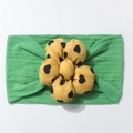 Cute green cable knit baby headband with a large yellow floral bow featuring heart patterns - Green