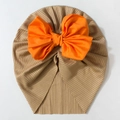 Detail of baby turban hat with a large orange bow on soft ribbed khaki fabric - Coffee