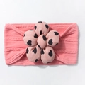 Detailed close-up of pink knitted baby headband with a soft heart-patterned fabric flower - Dust Rose
