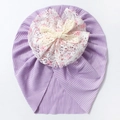 Detail of purple infant turban hat with tiered lace floral and crochet bow decoration - Purple