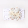 Détail de nœud en dentelle florale et mini papillon au crochet sur bandeau bébé - Blanc