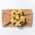 Detail view of baby headband with brown ribbed fabric and yellow flower with heart patterns - Brown