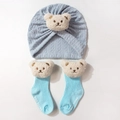 Detail of light blue baby turban hat and ribbed socks with cute white bear patches - Blue