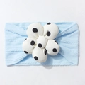 Detail of light blue ribbed knit baby headband featuring a plush white polka dot flower - Blue