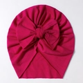 Detailed close-up of a magenta baby turban hat with a large bow and ribbed knit texture - Rose Red
